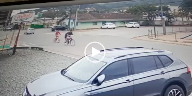 Um acidente que poderia ter sido fatal ocorreu na tarde desta sexta-feira (18) na rua Guaíra, bairro Iririú, zona Norte de Joinville. Dois adolescentes estavam em uma bicicleta e foram atravessar a rua sem olhar para trás e parar. Um carro que trafegava na rua não conseguiu frear e atingiu o ciclista e o caroneiro, que chegaram a voar com o impacto da batida – Foto: Reprodução/ND