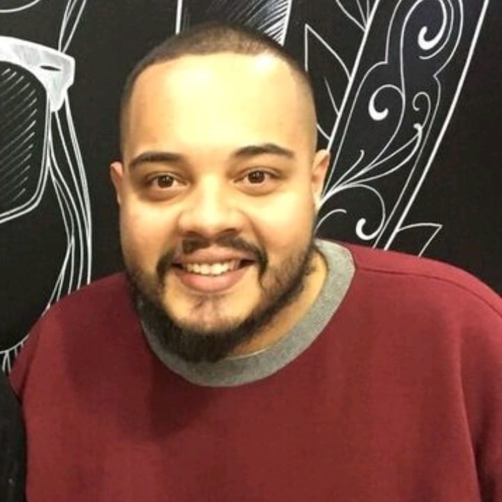 Paulo Ricardo Patrício sorri para foto e usa agasalho vermelho