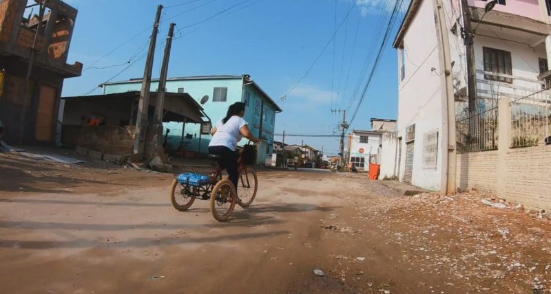 Mulher anda de bicicleta na comunidade Frei Damião, em Palhoça