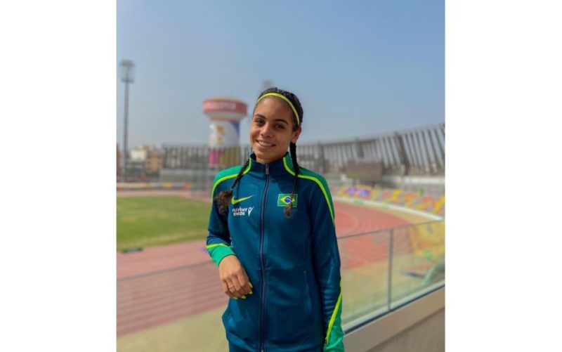 Lays Cristina sorri e usa casaco verde com o símbolo do Brasil