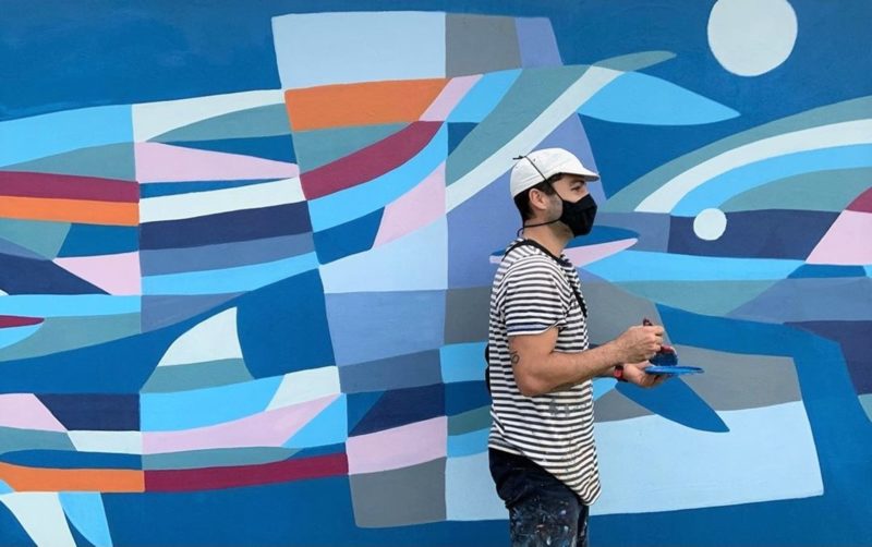 Pintando o mural “Família de Golfinhos Felizes no Encontro” (2021), na avenida Campeche, em Florianópolis – Foto: Anna Rezende/Divulgação/ND