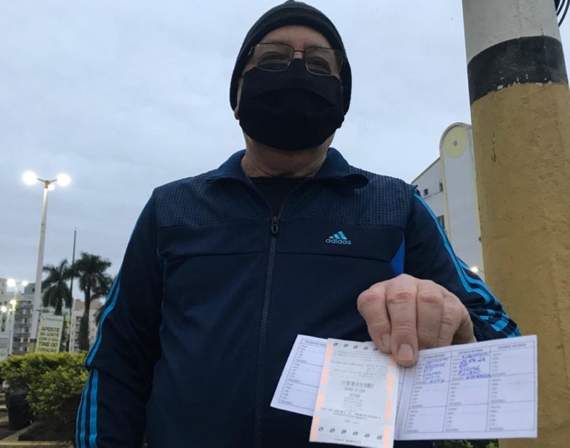 O torcedor José Jorge Ferreira exibe o ingresso e o comprovante de que tomou as duas doses da vacina a mais de 14 dias necessários para entrar no HH – Foto: Lucas Colombo/ND