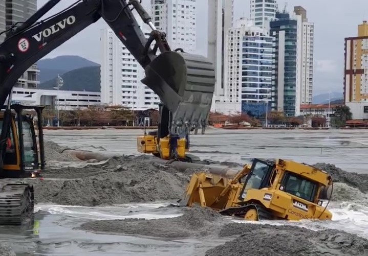 Areia &#8216;engole&#8217; máquina durante alargamento da praia de Balneário Camboriú &#8211; Foto: BC Minha Cidade/Reprodução