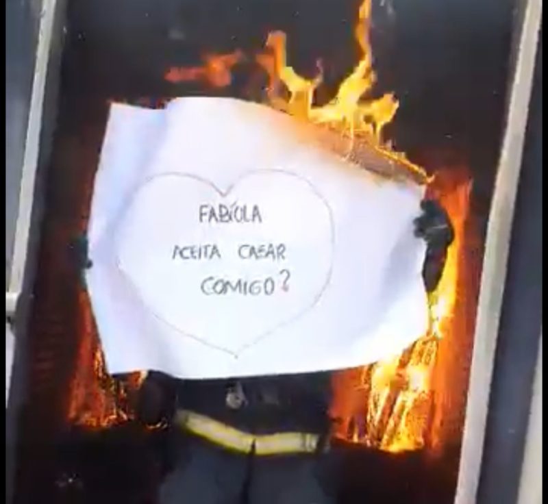 Com um cartaz o bombeiro militar, sargento Anderson Martins Cardoso pediu em casamento a namorada e bombeiro comunit&aacute;ria Fab&iacute;ola Sampaio em Laguna – Foto: Reprodu&ccedil;&atilde;o/Internet