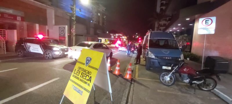 Imagem mostra viaturas da Guarda Municipal e na frente uma placa amarela onde é possível ler operação lei seca. Objetivo é encontrar motoristas dirigindo sob efeito de álcool