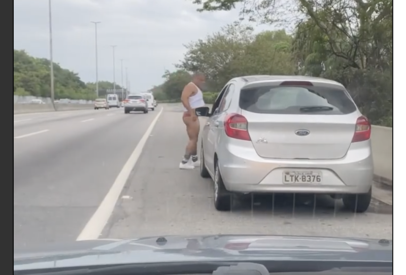 De calcinha, motorista tenta resolver problema do carro em via expressa movimentada do Rio – Foto: Reprodu&ccedil;&atilde;o