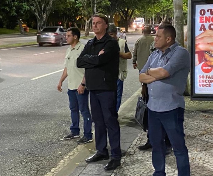 foto mostra presidente Bolsonaro parado em ponto de ônibus
