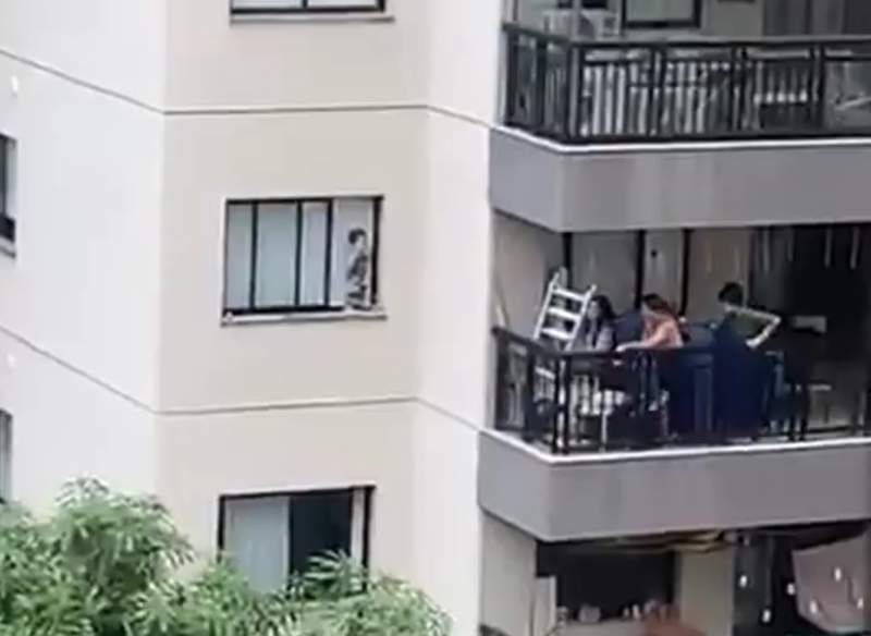 Imagens flagram o menino no parapeito enquanto pais est&atilde;o na varanda do apartamento – Foto: Reprodu&ccedil;&atilde;o