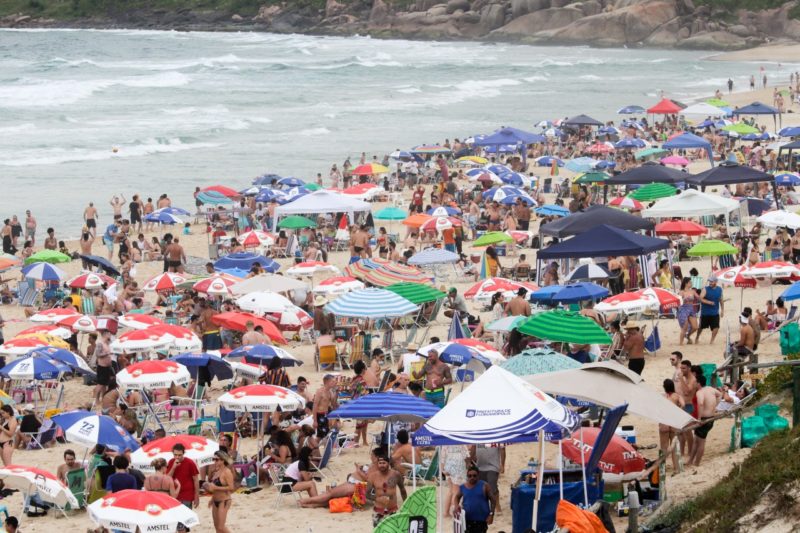 Foto mostra Praia Mole cheia de pessoas, onde fica o Selina Hostel