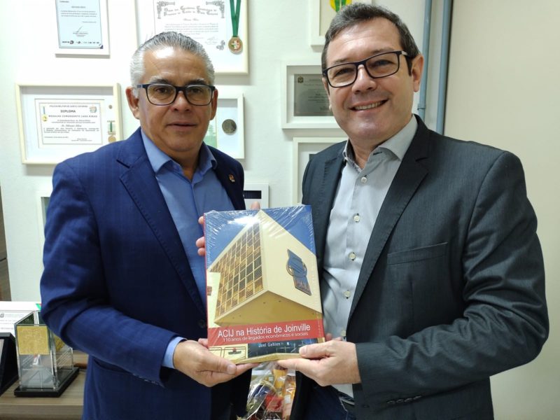 Marco Antonio Corsini, presidente da Acij, entrega livro para Silvano Silva, diretor do Grupo ND