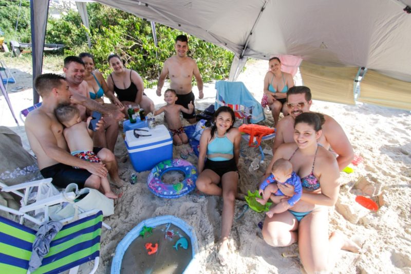 Família de turistas na praia da Daniela