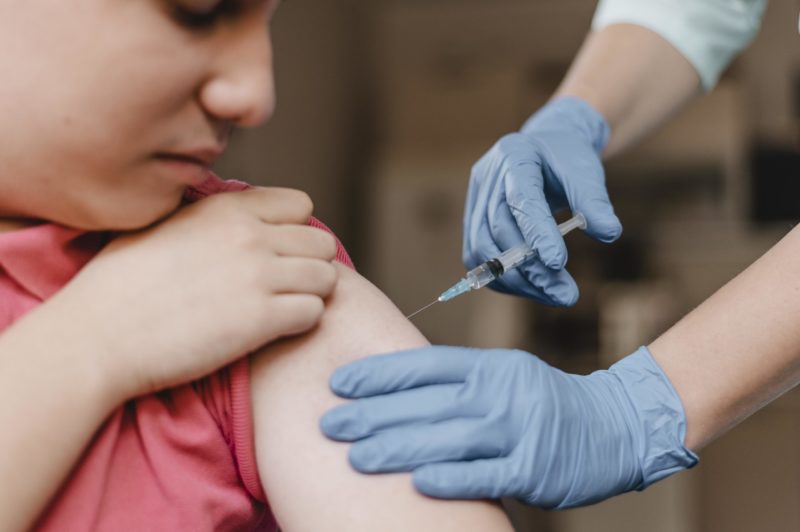 Criança recebe vacina no braço 