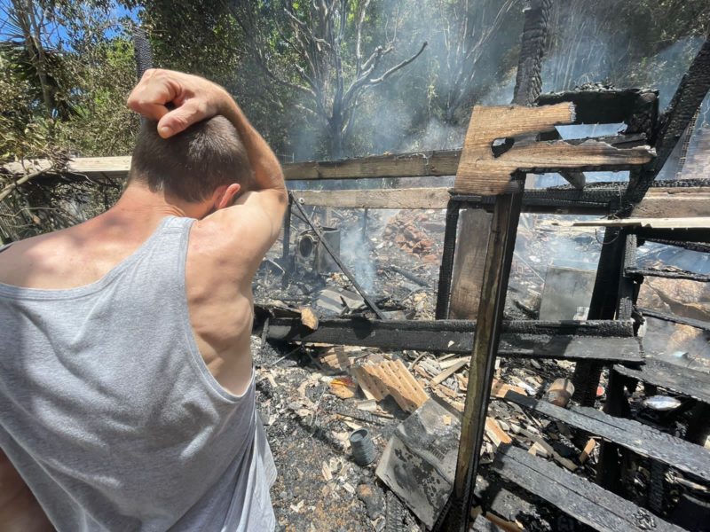 Morador diante da casa em incendiada na Trindade