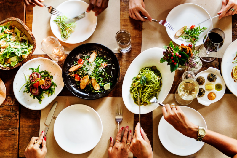 Mesa vista de cima com pratos de saladas e molhos para ilustrar matéria sobre bares e restaurantes em SC
