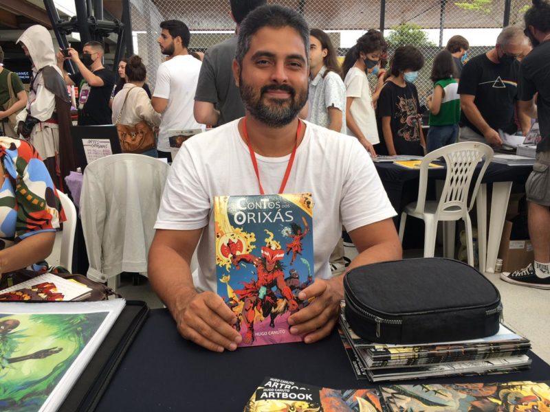 Hugo segurando sua obra mais conhecida, O conto dos Orix&aacute;s – Foto: Julia de Araujo/Reprodu&ccedil;&atilde;o/ND