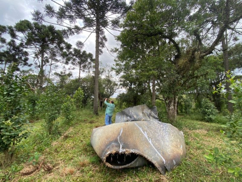 Morador ao lado da pe&ccedil;a de metal retorcida – Foto: Portal RDX/ND