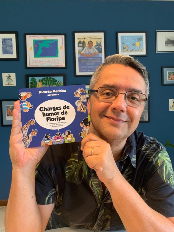 Ricardo Manh&atilde;es e livro Charges de Humor de Floripa – Foto: Divulga&ccedil;&atilde;o/ND
