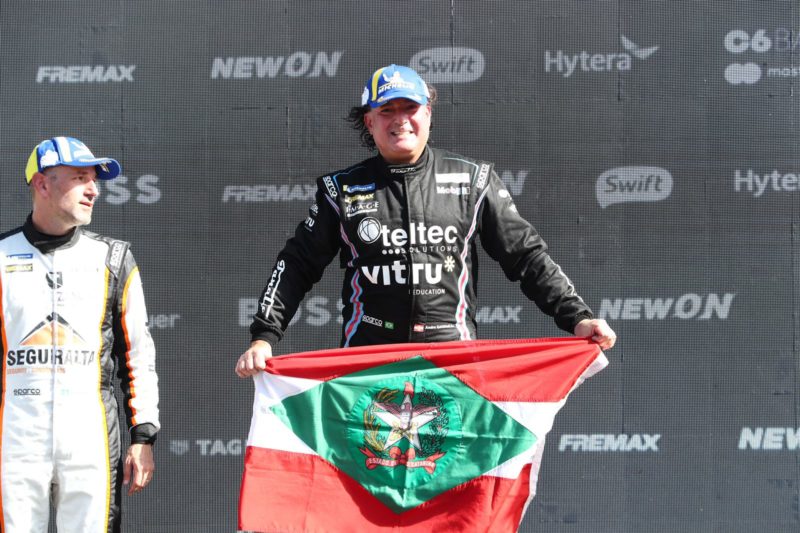 Piloto Andr&eacute; Gaidzinski com a bandeira de SC no p&oacute;dio da Porsche Cup Brasil – Foto: Luca Bassani