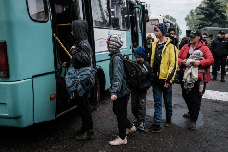 Fam&iacute;lias esperam por &ocirc;nibus disponibilizado pela Unidade estatal de resgate para evacua&ccedil;&atilde;o, em Lyman, no Leste da Ucr&acirc;nia – Foto: Yasuyoshi CHIBA/AFP