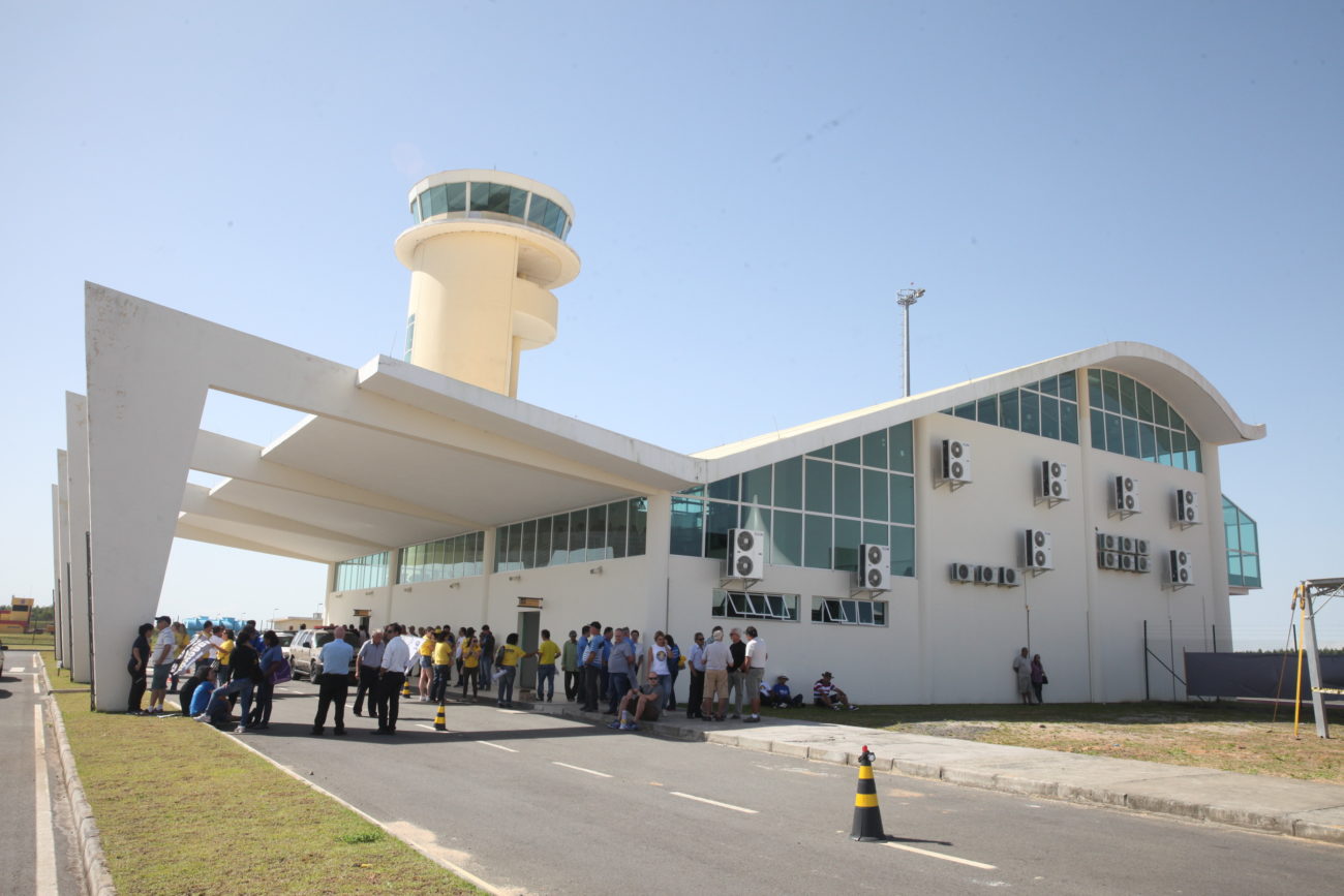 Foto externa do Aeroporto de Jaguaruna com uma fila de passageiros fora