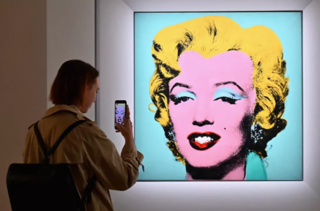 A tela de pouco mais de um metro quadrado com Marilyn Monroe pintada em fundo rosa &eacute; a estrela do leil&atilde;o – Foto: Angela Weiss/AFP/ND