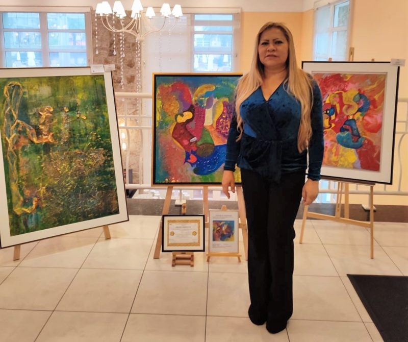 Leda Risse junto de suas pinturas, no IL Campanario Villaggio Resort – Foto: Divulgação/ND