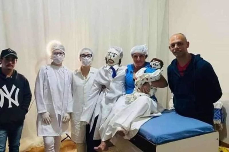 Mulher durante encenação do parto do boneco