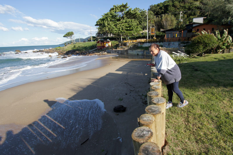 L&uacute;cia Prazeres, de 61 anos, diz que j&aacute; gastou R$ 130 mil entre m&atilde;o-de-obra e preju&iacute;zos causados pelo avan&ccedil;o do mar – Foto: Leo Munhoz/ND