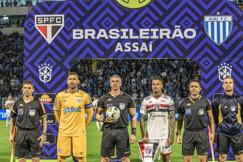 Anderson Daronco (entre os dois jogadores) durante Avaí e São Paulo