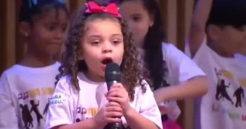 A pequena Laura canta em tom l&iacute;rico, como se fosse uma cantora de &oacute;pera – Foto: Reprodu&ccedil;&atilde;o