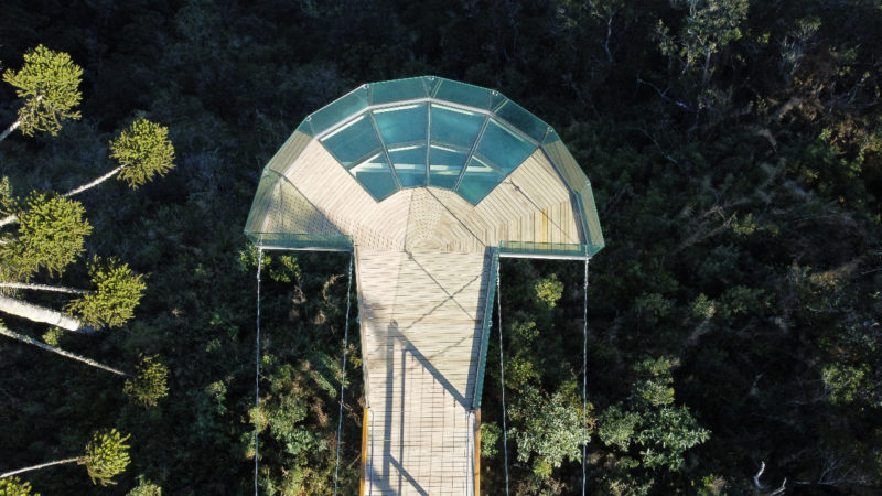Na imagem aparece uma passarela de vidro vista de cima