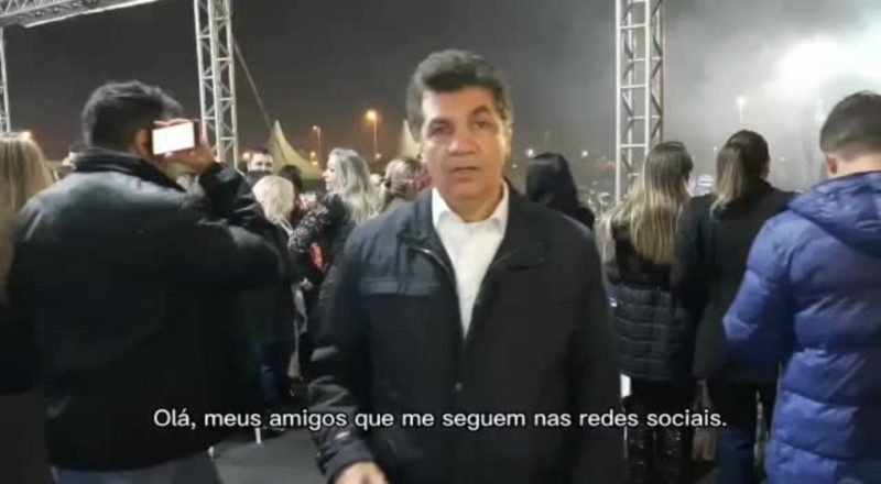 Clesio Salvário fala em vídeo com público ao fundo
