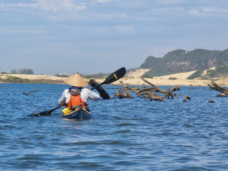 Na imagem aparece uma pessoa de costas fazendo canoagem no Rio Araranguá