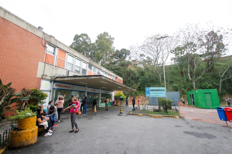 Imagem mostra frente do Hospital Infantil Joana de Gusmão, em Florianópolis. O céu aparece nublado e algumas pessoas estão em frente do hospital