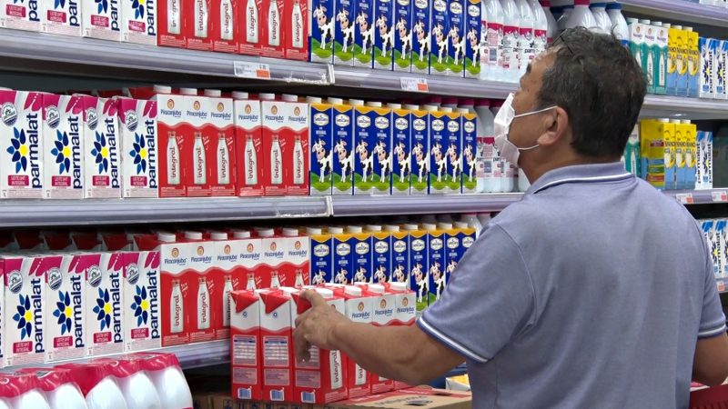 Homem escolhendo leite em mercado