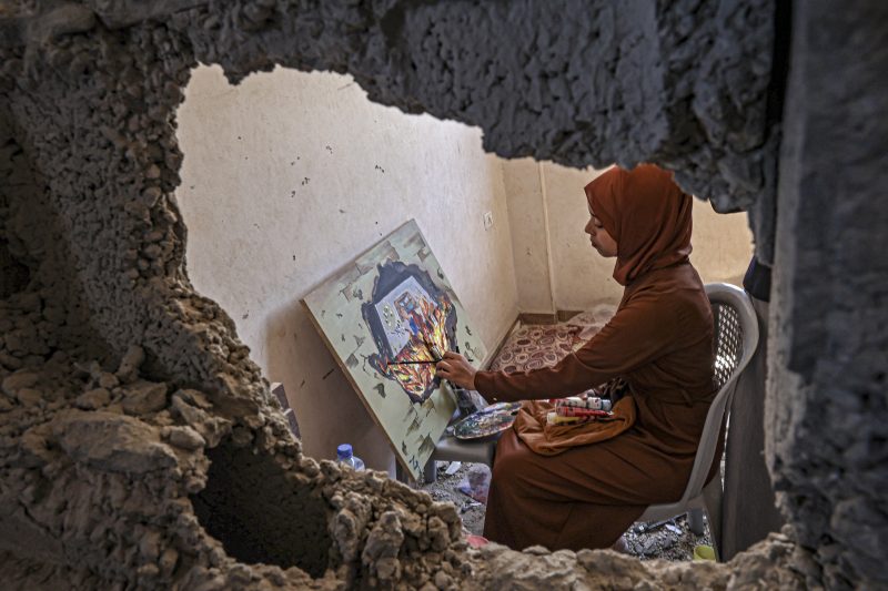 Artista palestina pinta em exposi&ccedil;&atilde;o organizada pela Associa&ccedil;&atilde;o de Cultura e Livre Pensamento na casa de Diana al-Amour, morta por um bombardeio israelense no sul da Faixa da Gaza – Foto: SAID KHATIB/AFP/ND
