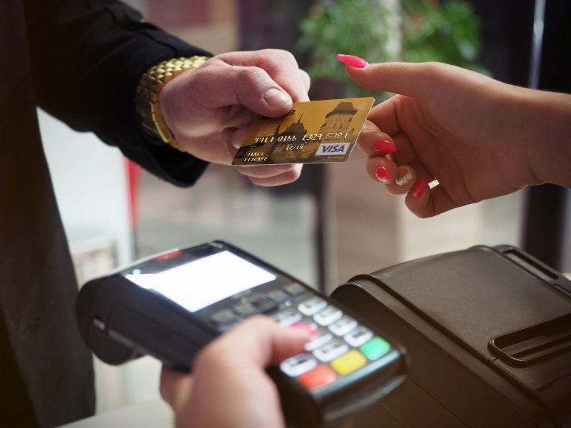 Imagem mostra pessoa entregando cartão de crédito para outra pessoa que segura uma máquina de cartão, Desenrola é um programa de renegociação de dívidas, que abrange as de cartão de crédito