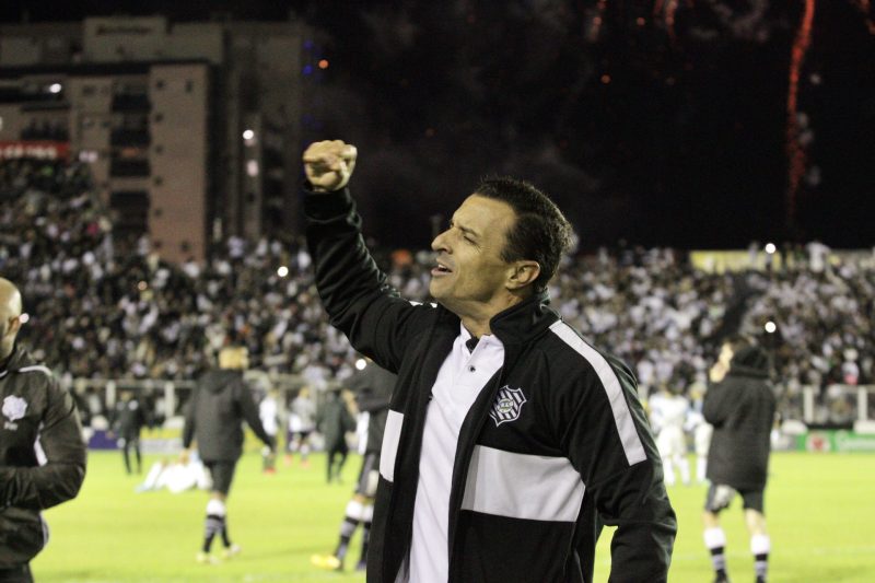 Técnico Júnior Rocha comemora com punho cerrado em estádio do Figueirense