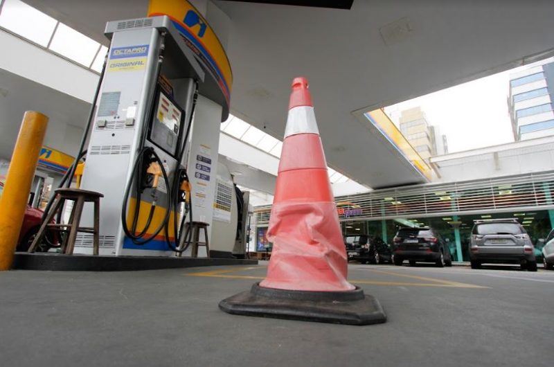 Imagem mostra um cone em frente de uma bomba de gasolina