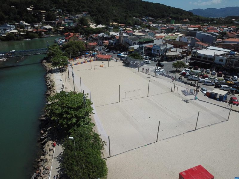 Pessoas jogando basquete em quadra poliesportiva pública na orla