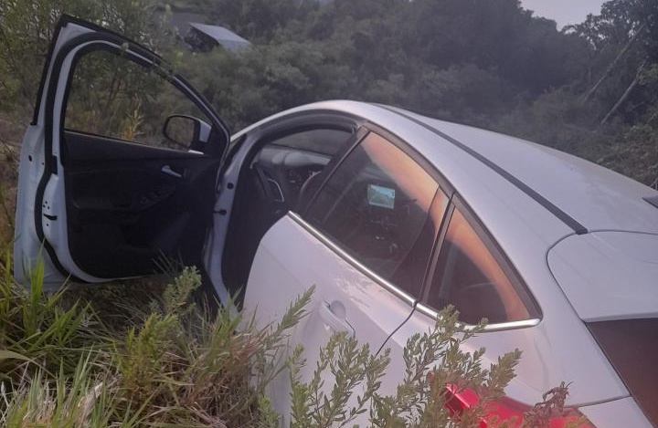 O carro ficou suspenso no penhasco, com a porta do motorista aberta. &mdash; Foto: Pol&iacute;cia Militar/Reprodu&ccedil;&atilde;o