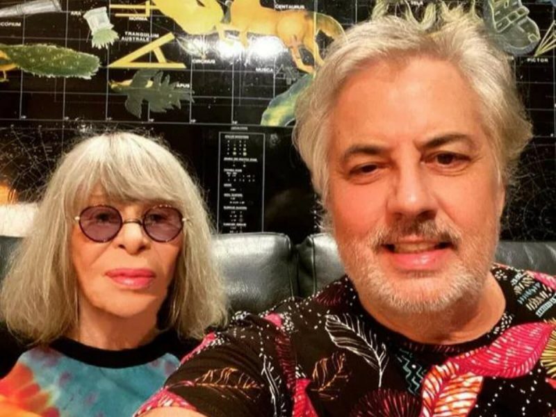 na foto Rita Lee aparece à esquerda de óculos enquanto que Roberto d Carvalho mais à direita