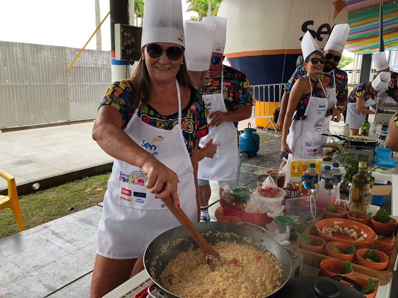 A pedagoga Rosa Helena participa há dez anos do concurso gastronômico com o mesmo prato, que aprimora a cada nova edição. “Esse ano é o risoto do rei. Esse ano tem algumas coisas mais ‘gourmet’ e todo ano a gente ganha experiência, novas amizades, porque a festa do Berbigão significa isso para a gente”, resume – Foto: Júlia Venâncio/ND