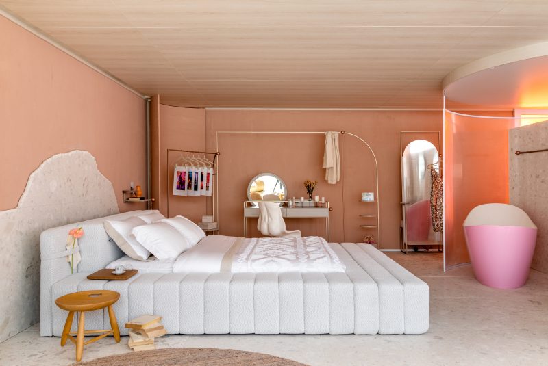 O recorte natural de pedra na parede traz eleg&acirc;ncia &agrave; cabeceira da cama – Foto: Divulga&ccedil;&atilde;o