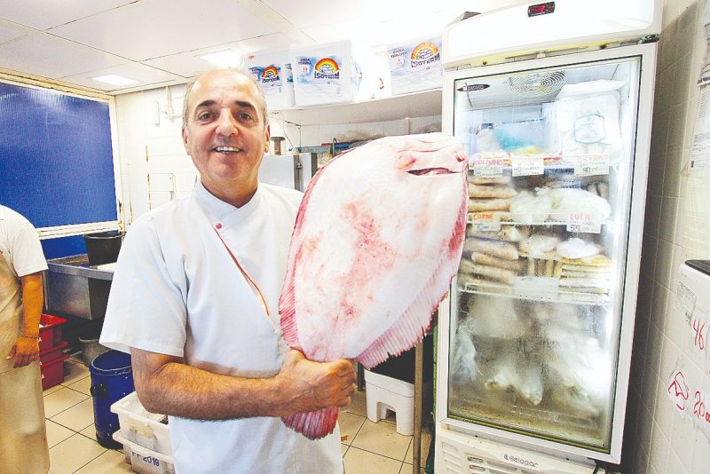 Comerciantes do Mercado P&uacute;blico esperam boas vendas na Semana Santa. Na foto, o dono de peixaria Ronaldo Oliveira exibe um linguado. – Foto: L&eacute;o Munhoz/ND