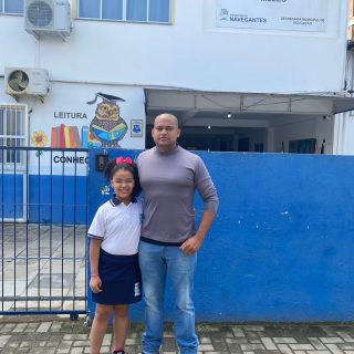 Voluntário Lázaro de Oliveira Silva e sua filha em frente a EM Professora Ilka Muller de Mello