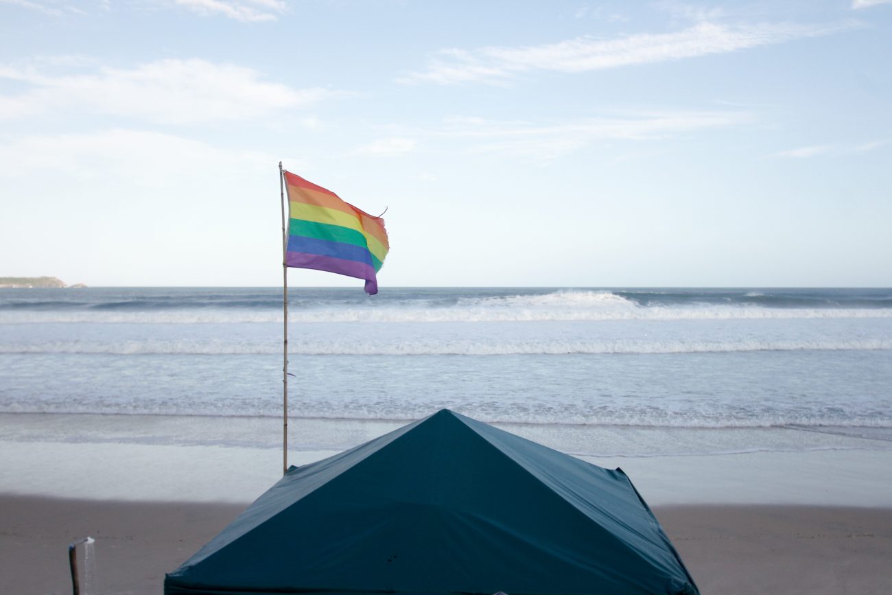 Bandeira LGBTQIAPN+ na beira da praia