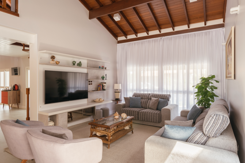 Com p&eacute; direito alto e telhado de madeira, a sala de televis&atilde;o realizada &eacute; perfeita para um clima invernal – Foto: Henrique Ribeiro/Divulga&ccedil;&atilde;o/ND