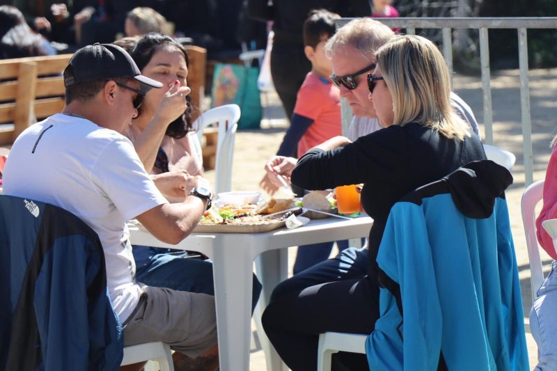 Foto de pessoas comendo na Festa do Bom Sucesso, em Balneário Camboriú