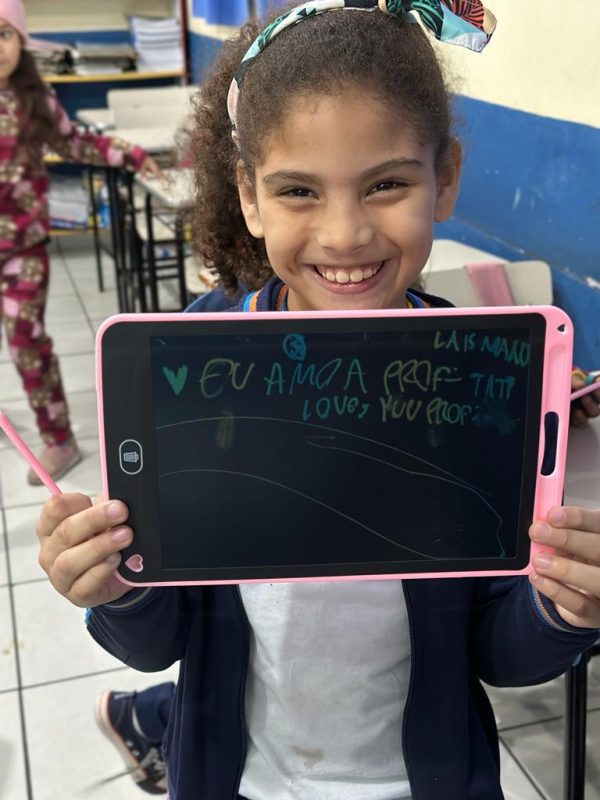 Estudante do CEM segurando a lousa digital